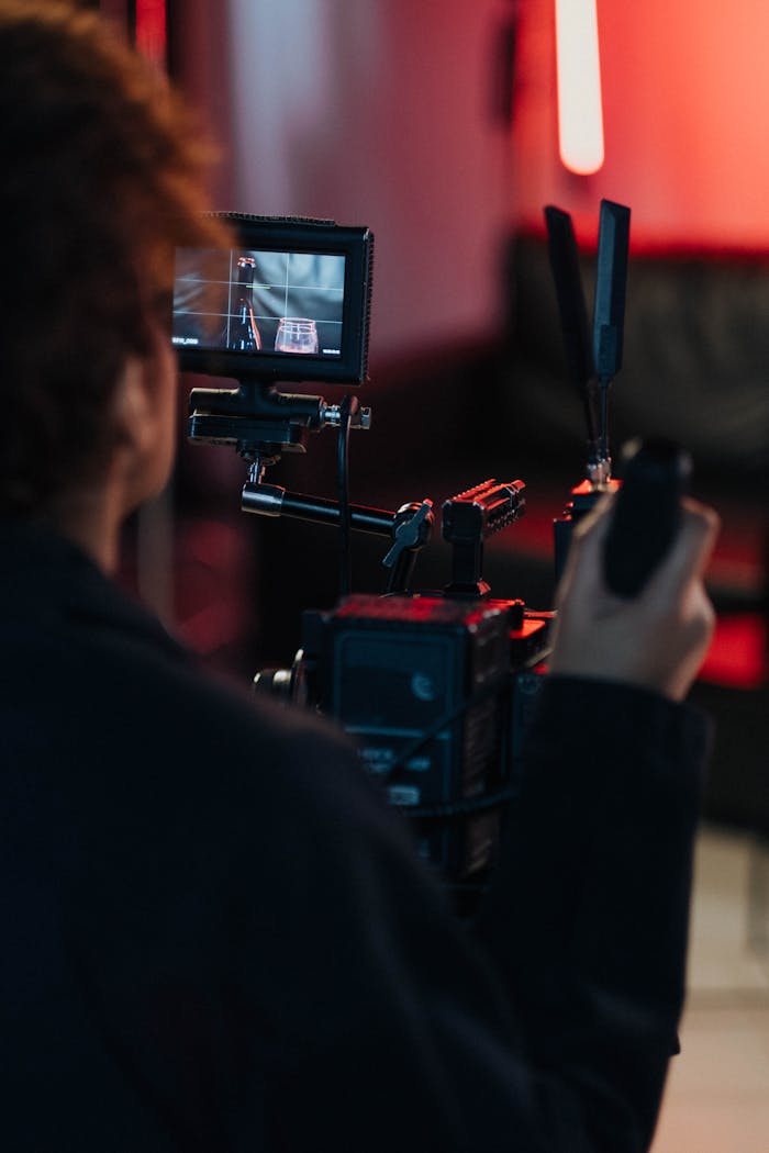 Behind-the-scenes look at a videographer filming with advanced equipment in a studio setting.